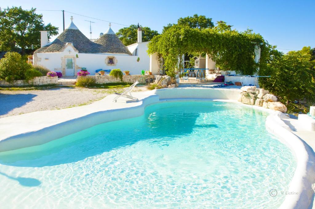 una piscina di fronte a una casa di Trulli Terra Magica a Putignano