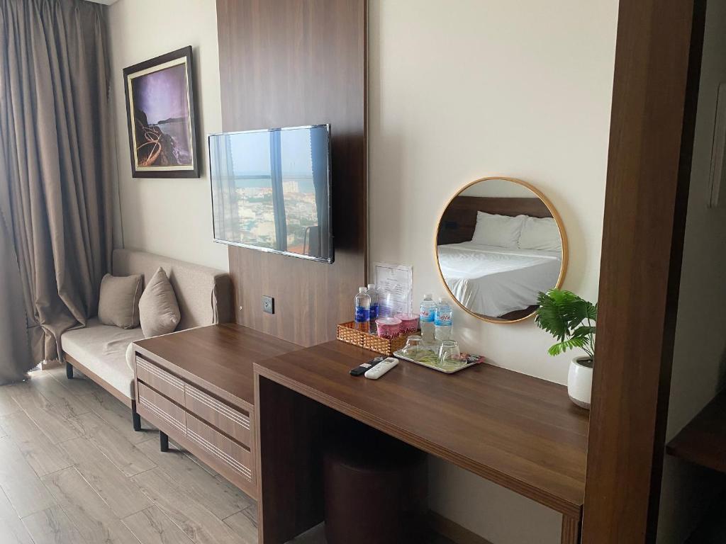 Cette chambre comprend un bureau et un miroir. dans l'établissement Căn hộ Condotel 5 sao Apec Tuy Hòa Phú Yên, à Tuy Hoa