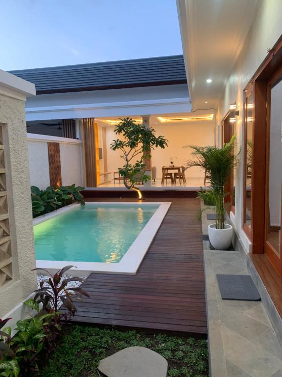 a swimming pool in the middle of a house at Wikans Villa in Kuta