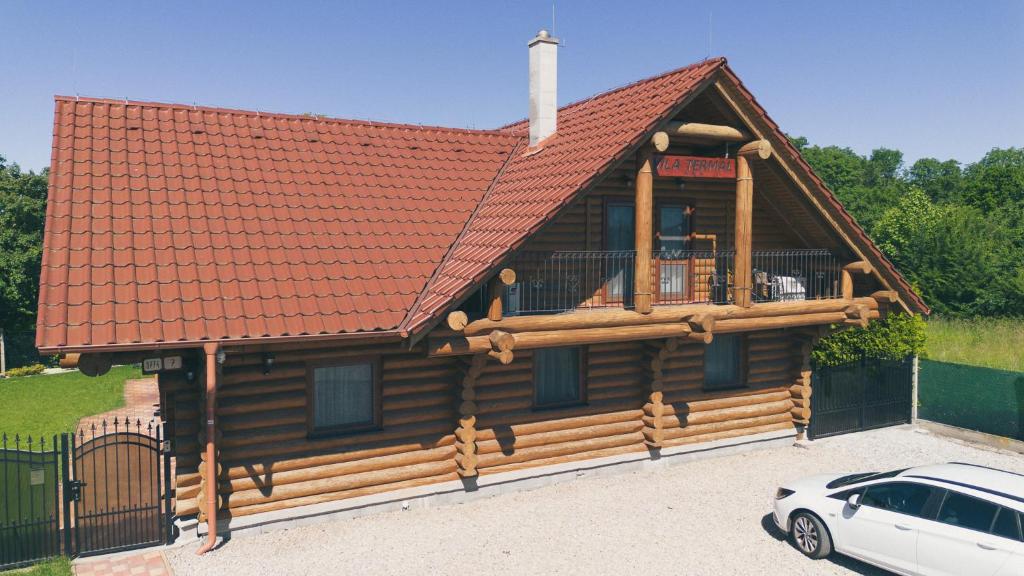 a log cabin with a car parked in front of it at Vila Termal in Veľký Meder