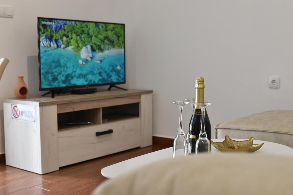 a living room with a television on a wooden entertainment center at KenDar Premium Apartments in Ulcinj