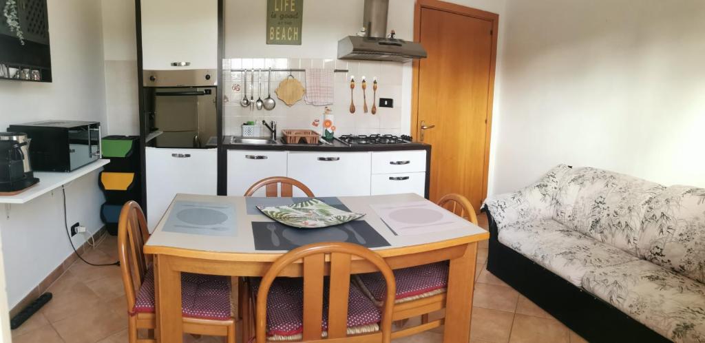 een kleine keuken met een tafel en een bank bij Casa Deborah in Fontane Bianche