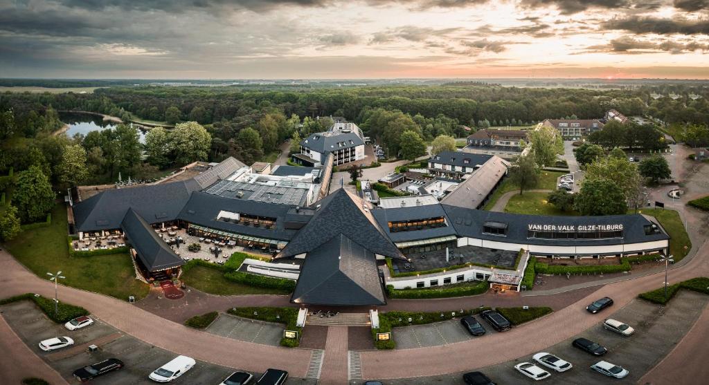 uma vista aérea de um grande edifício com estacionamento em Van der Valk Hotel Gilze-Tilburg em Tilburgo