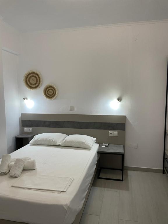 1 dormitorio con 1 cama blanca grande y escritorio en Sunshine Apartments and Rooms, en Nikiana