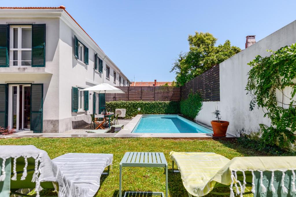 un cortile con piscina e una casa di Haus Abel - pool, parking and garden in the heart of Lisbon a Lisbona