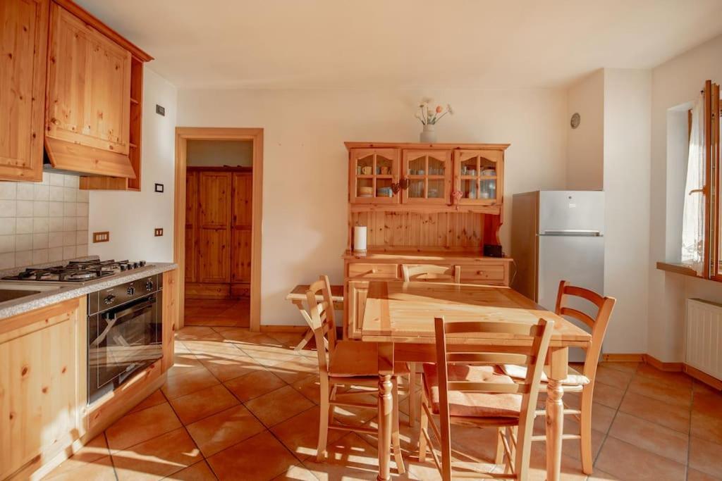 una cucina con tavolo, sedie e frigorifero di Mountain Bliss Retreat - 20min from Cortina a Borca di Cadore