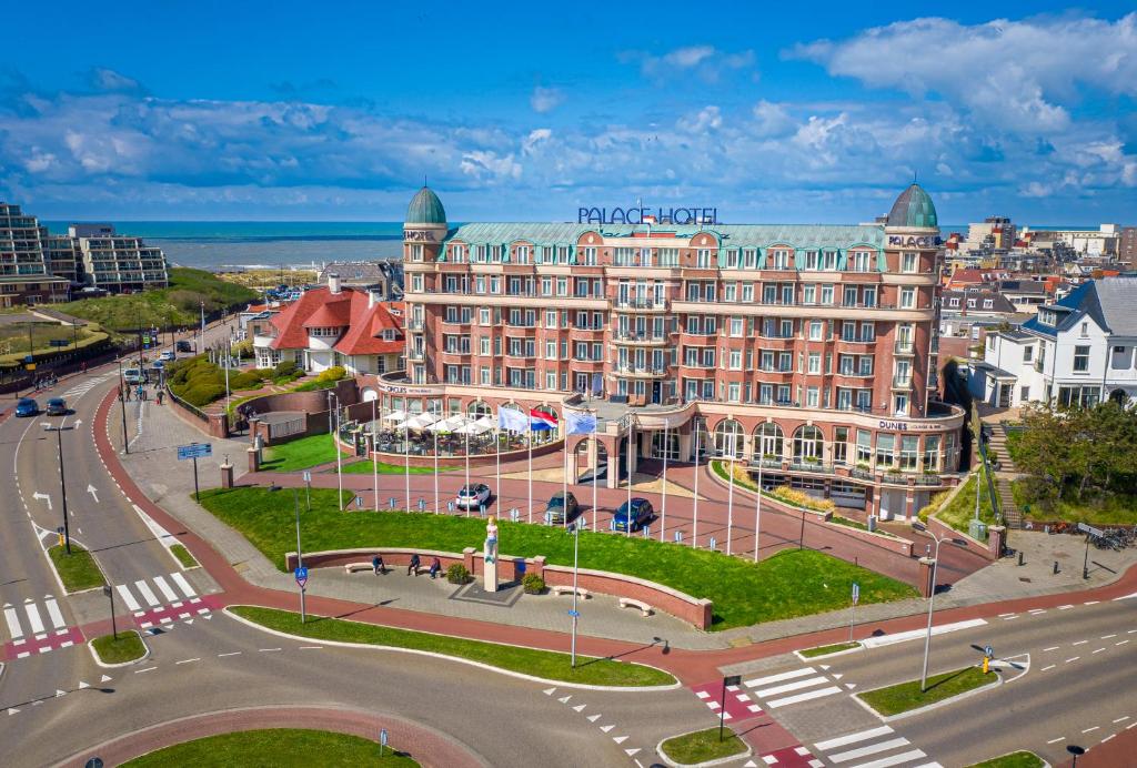 Van der Valk Palace Hotel Noordwijk في نوردفايك أن زي: مبنى كبير في مدينة بها شارع