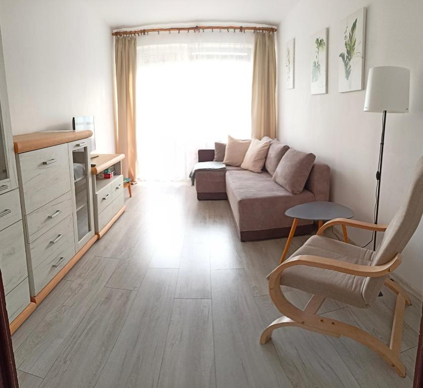 sala de estar con sofá y silla en Apartament Mazury, en Olecko