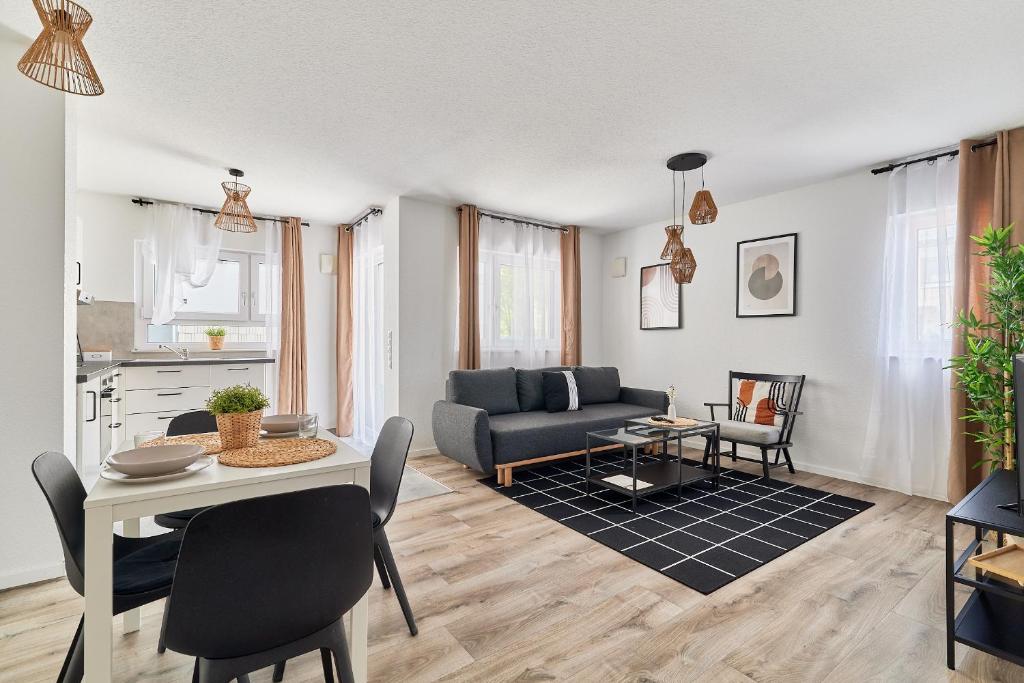 ein Wohnzimmer mit einem Tisch und einem Sofa in der Unterkunft Elegantes 2 Zimmer Apartment Neubau Ruhige Lage in Mannheim