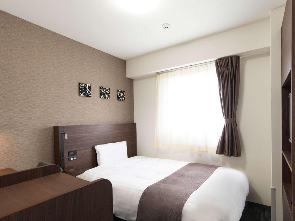 Voodi või voodid majutusasutuse Comfort Hotel Wakayama toas