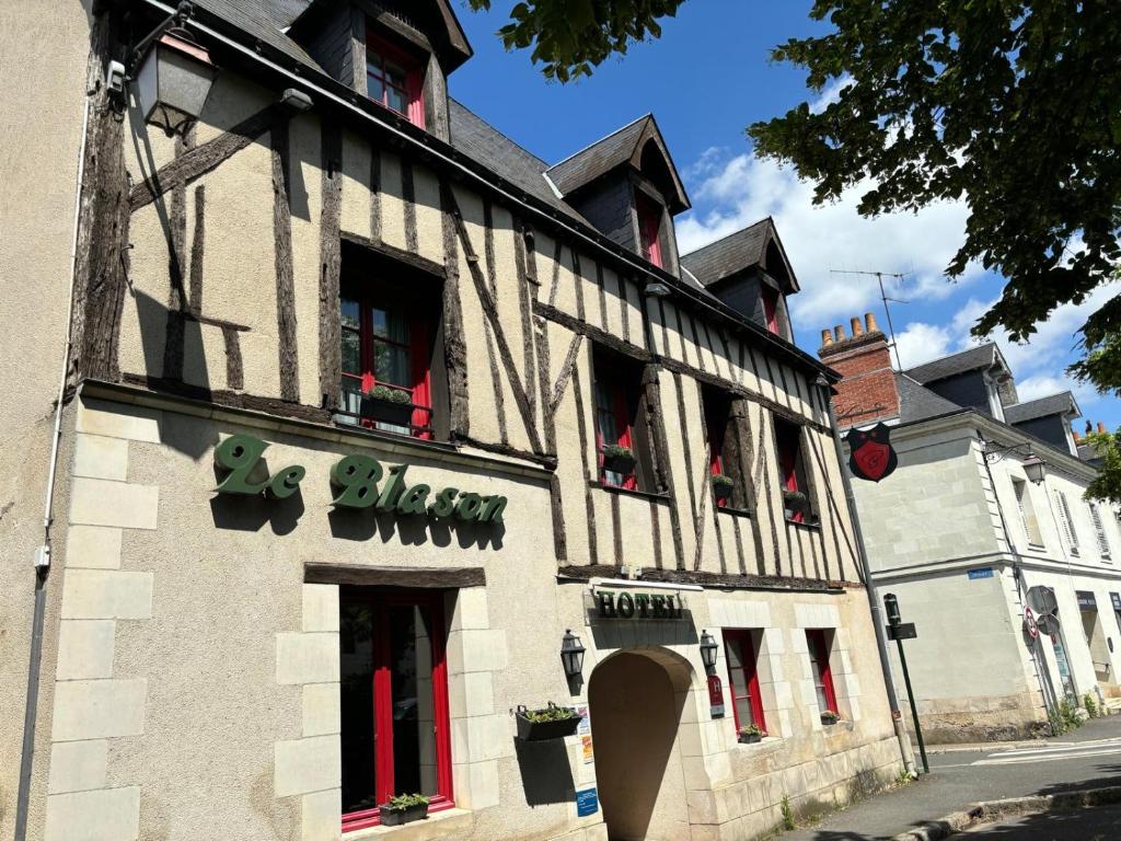 een gebouw met rode deuren en ramen in een straat bij Hôtel Le Blason in Amboise