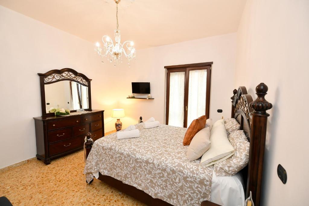 a bedroom with a bed and a dresser and a mirror at B&B Family in Torre del Greco