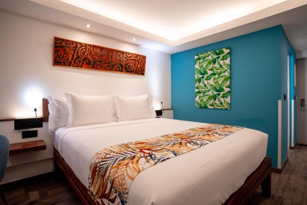 um quarto com uma cama grande e uma parede azul em Maitai Express Tahiti em Papeete