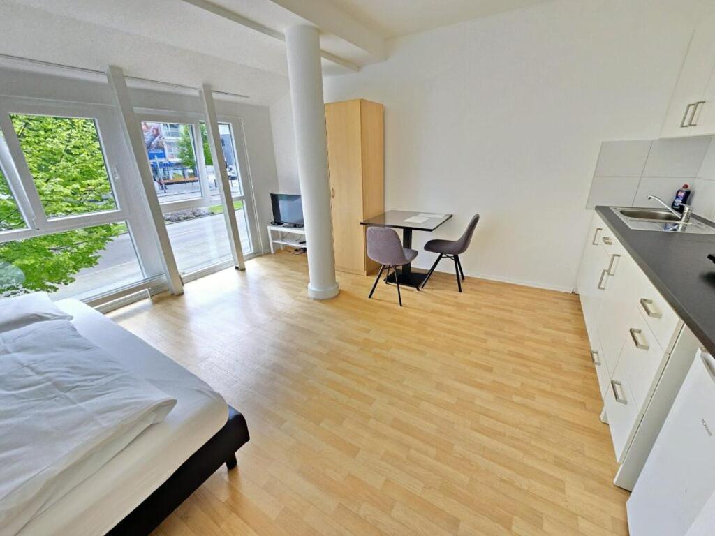 Cet appartement comprend une chambre avec un lit et une cuisine avec une table. dans l'établissement Apartments EFDE GmbH, à Heilbronn