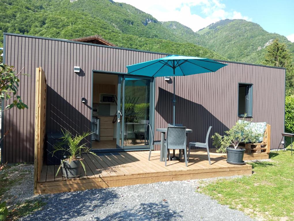 eine Terrasse mit einem Tisch und einem Sonnenschirm in der Unterkunft Maisonnette au calme in Marlens