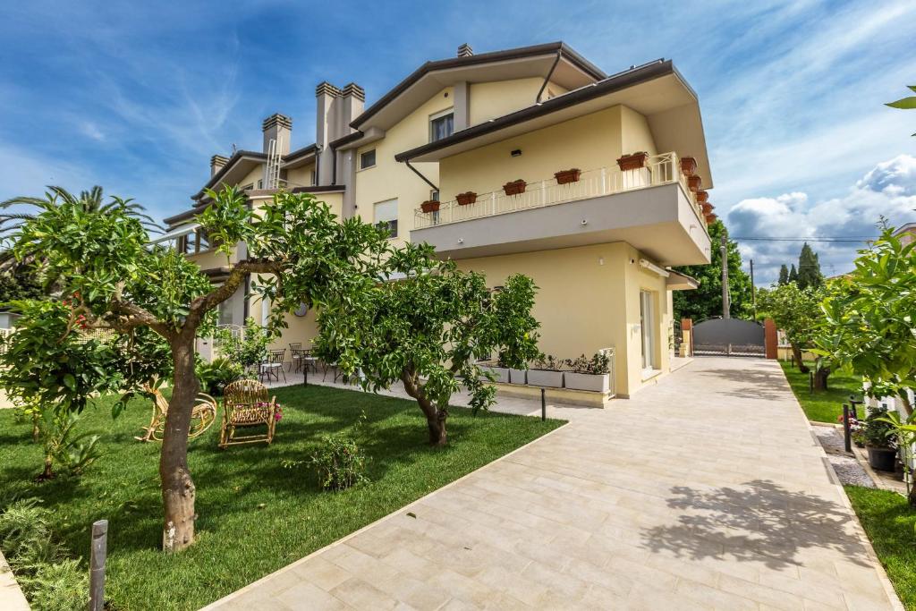 a villa with a garden and a driveway at Casa Rita in Sabaudia