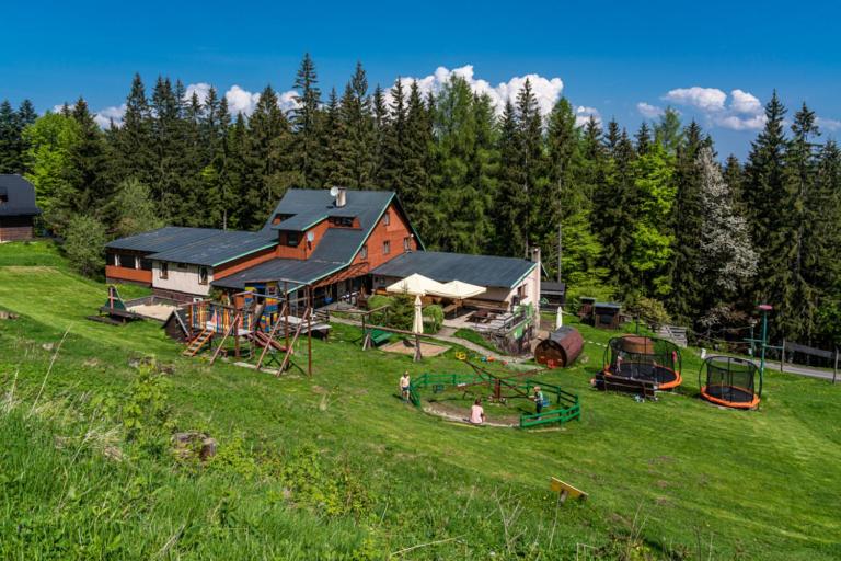 ein Haus mit Spielgeräten auf einem Feld in der Unterkunft Bačkárka - horská chata in Makov