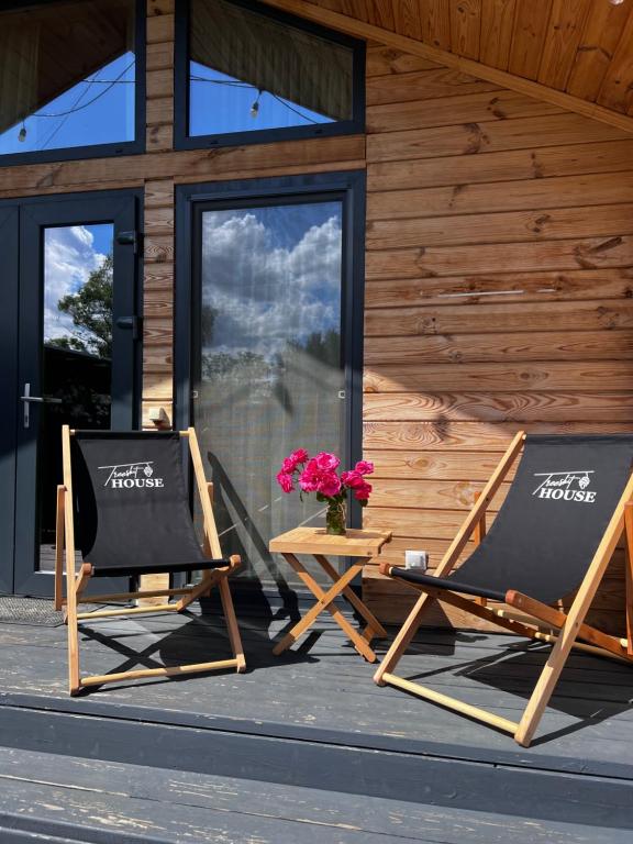 - deux chaises et une table sur une terrasse couverte fleurie dans l'établissement Treeskit House, à Horenka