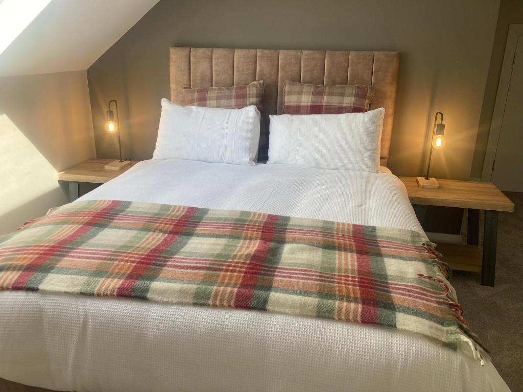 - une chambre avec un grand lit et une couverture tressée dans l'établissement Luxury Country Escape, à Ennis