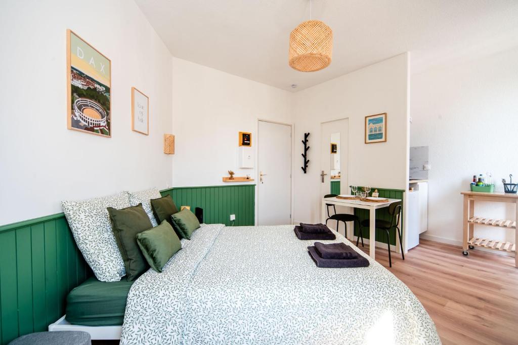 um quarto verde e branco com uma cama e uma mesa em Le Studio Saint-Pierre - Dax em Dax