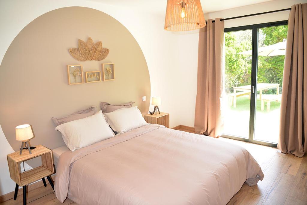 a bedroom with a large bed and a large window at Casa Solana - Piscine privée et chauffée in Galeria