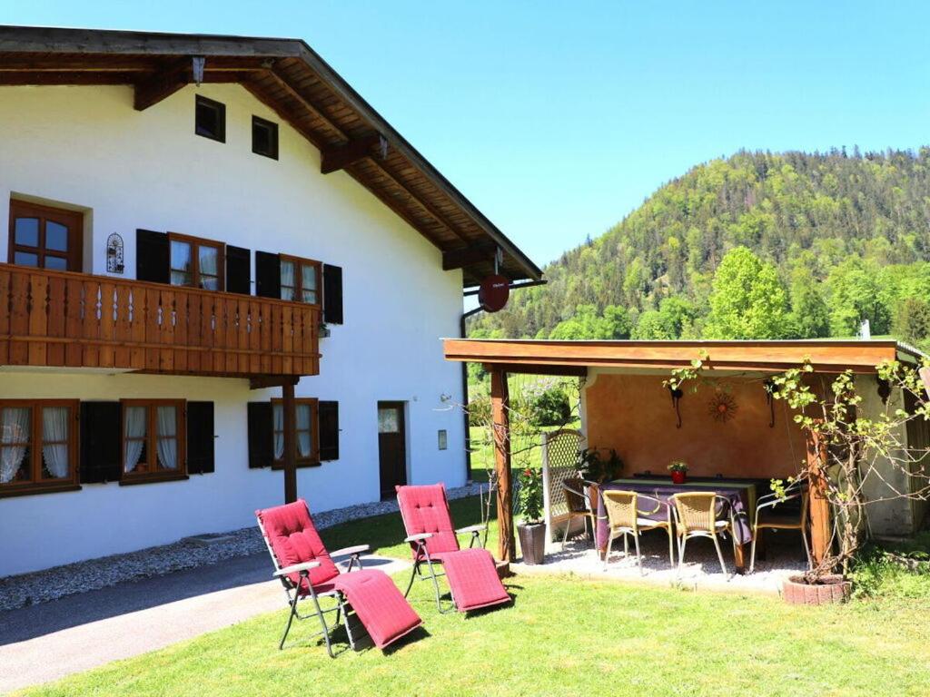 eine Terrasse mit roten Stühlen und einem Tisch vor einem Haus in der Unterkunft Rossfeld Modern retreat in Berchtesgaden