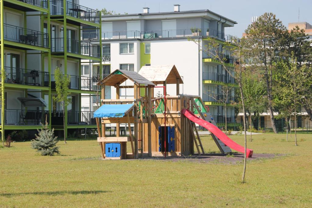 einen Spielplatz mit Rutsche und Spielhaus in der Unterkunft Ale Apartman Siófok in Siófok