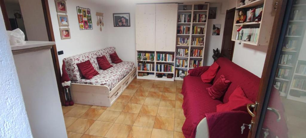 a living room with a red couch and book shelves at Alexi cir 0009 in Chambave