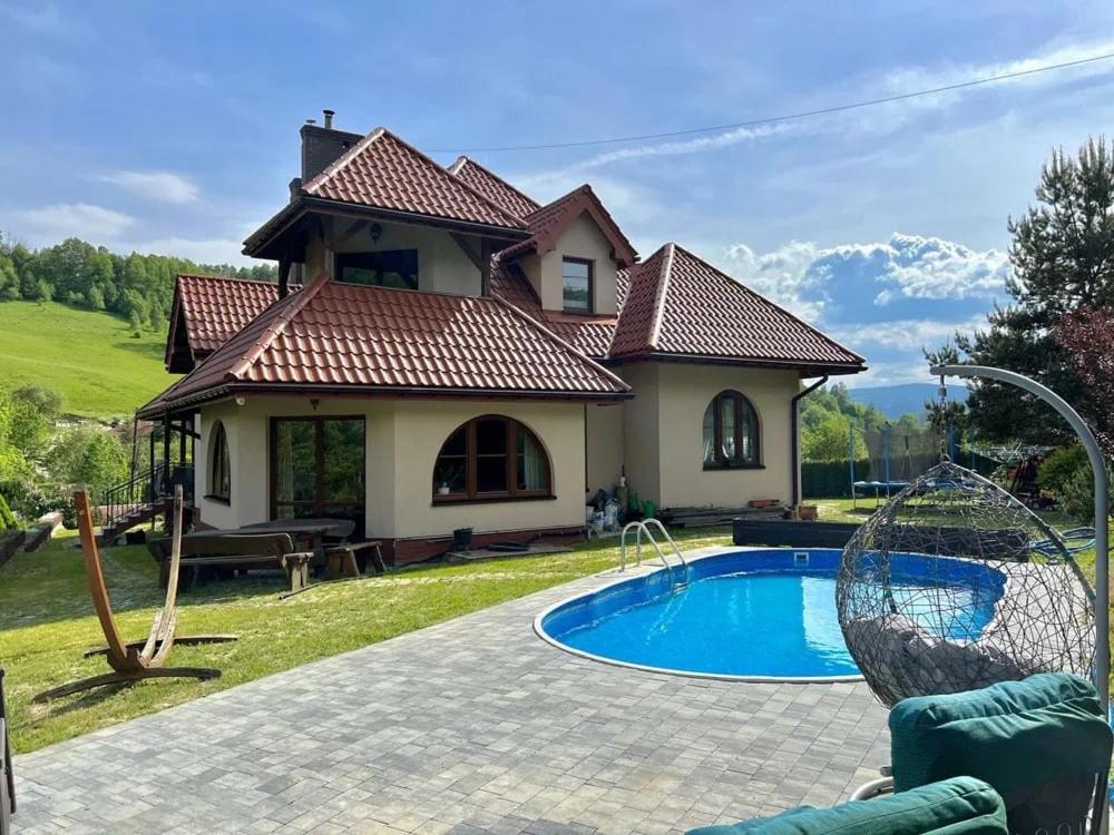 une maison avec une piscine dans la cour dans l'établissement Apartament Zimowa Cisza, à Piwniczna-Zdrój