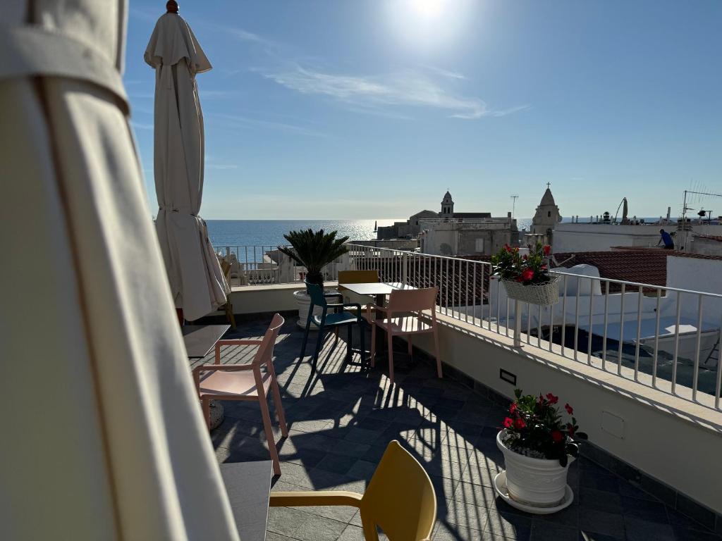 uma varanda com uma mesa e cadeiras e um guarda-sol em Estlevante B&B em Vieste