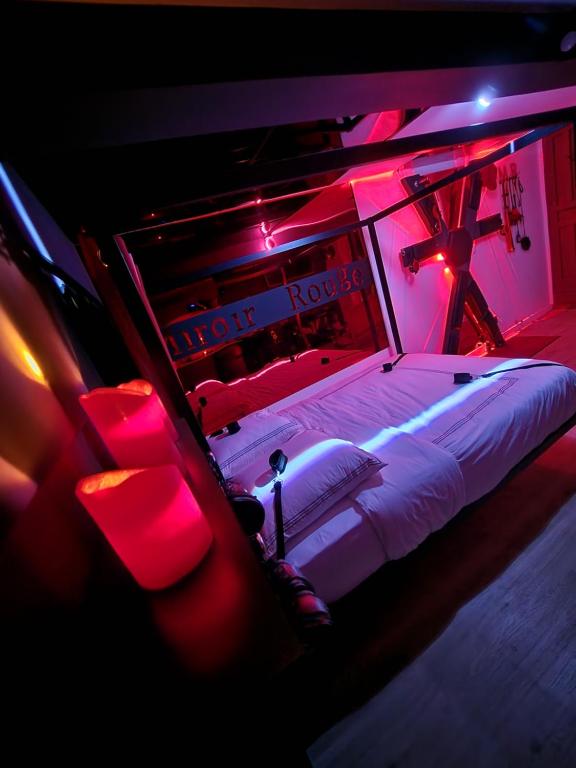 a bedroom with a bed in a room with red lights at Studio Le Miroir Rouge in Meaux