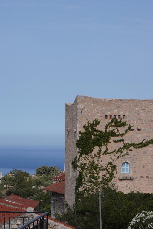 un grand bâtiment en briques avec une fenêtre et un arbre dans l'établissement Èlia Luxury Rooms, à Areópoli