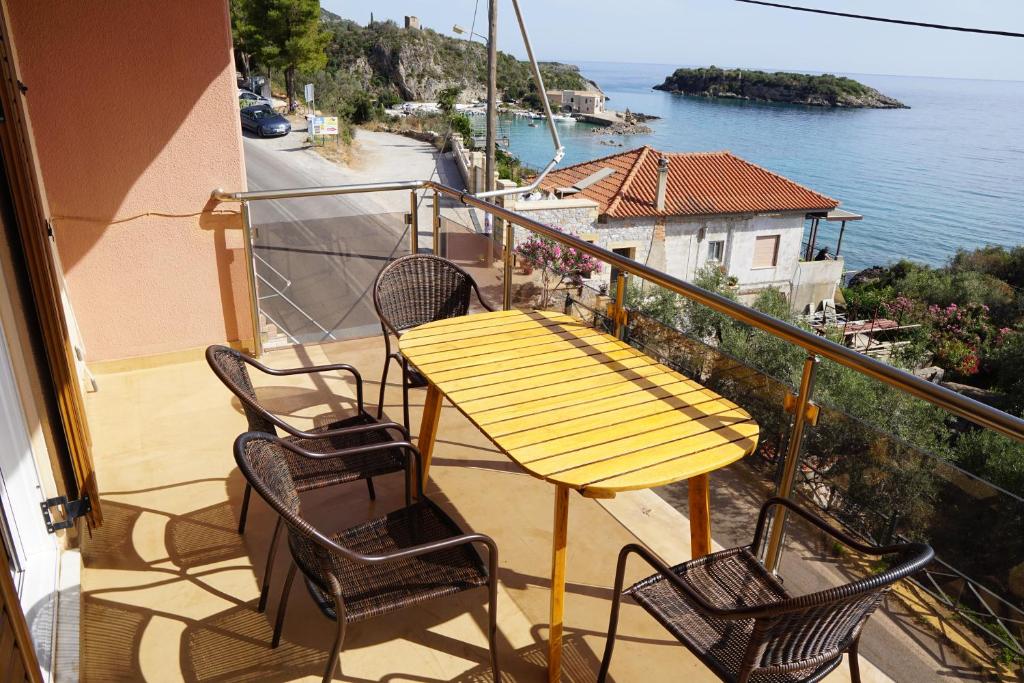 une table et des chaises jaunes sur un balcon donnant sur l'eau dans l'établissement Sea And Sun apartments 303 Ιδιωτικό διαμέρισμα, à Kardamyli