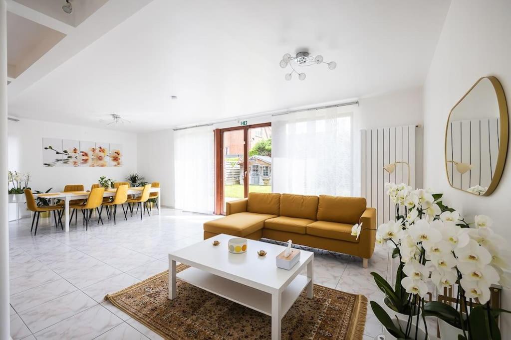 uma sala de estar com um sofá e uma mesa em Résidence Orchidée em Zaventem