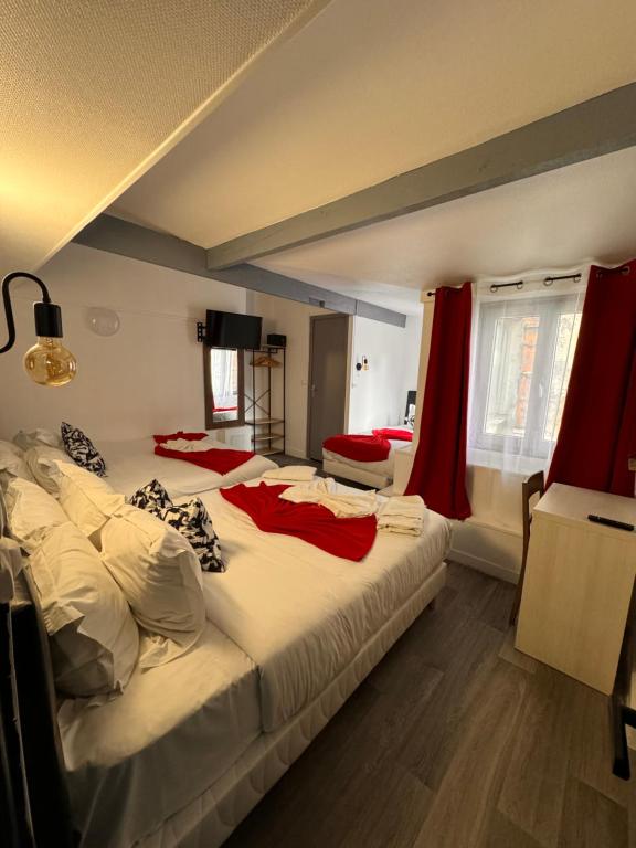 1 dormitorio con 2 camas y cortinas rojas en HOTEL LOUVAIN, en París