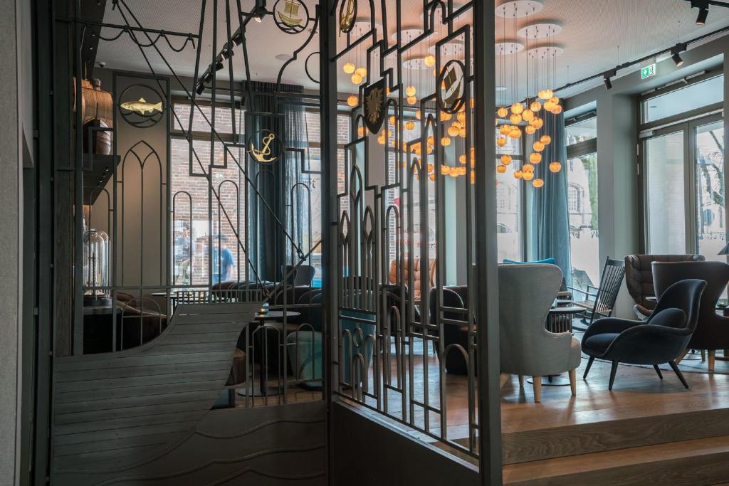 un restaurante con una escalera y sillas en una habitación en Motel One Lübeck, en Lübeck