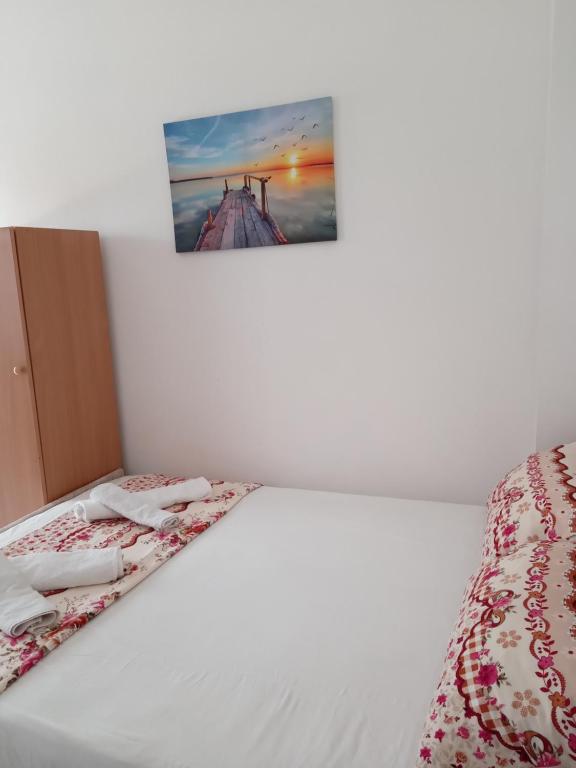 1 cama en una habitación con una foto en la pared en Prime rooms, en Durrës