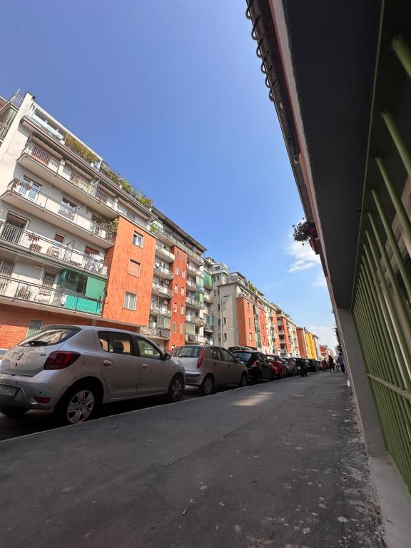 een rij auto's geparkeerd op een straat met gebouwen bij Suite Bohémien Chic - A 5 Fermate dal Duomo in Milaan