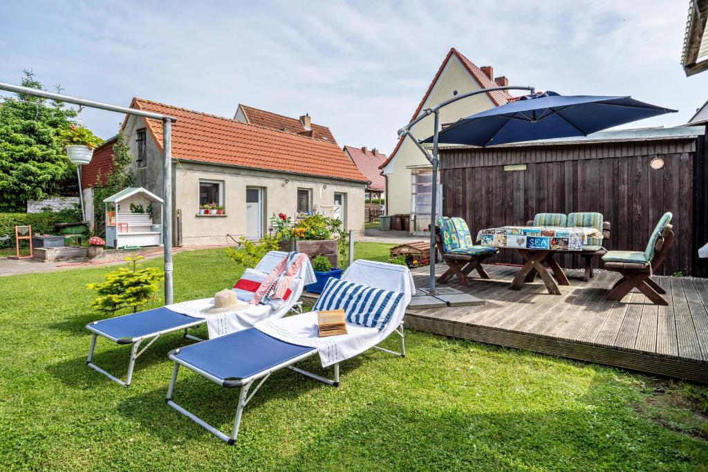 un patio con mesa, sillas y sombrilla en Ferienwohnung auf der Insel Rügen, en Bergen auf Rügen