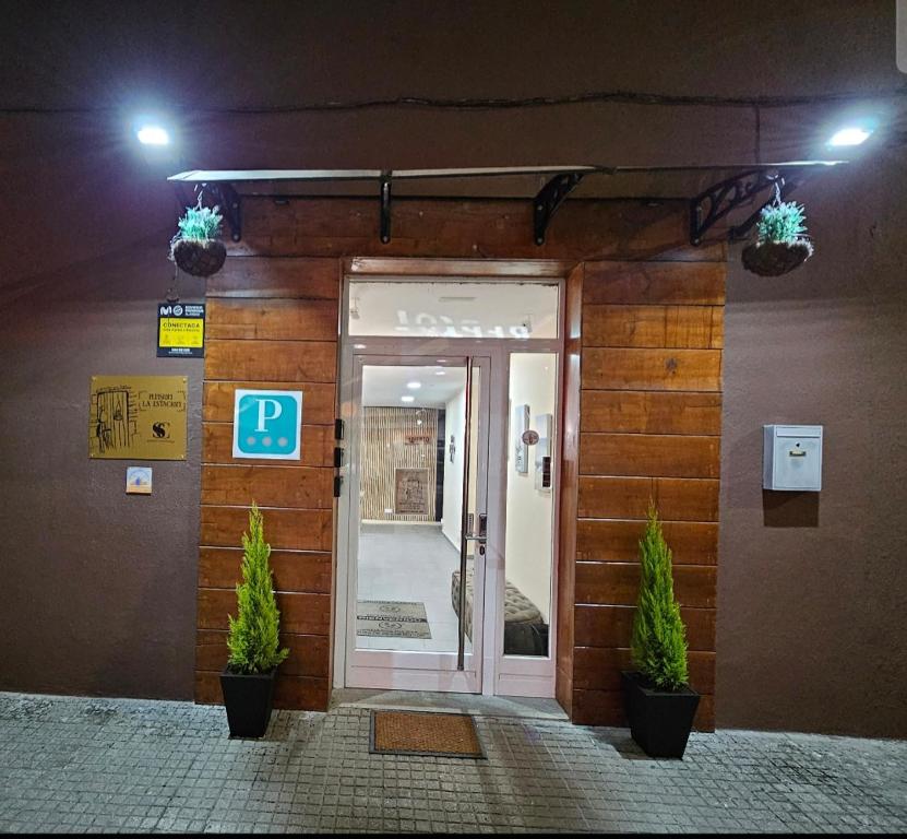 una puerta delantera de un edificio con un cartel en Pensión La Estación, en Sarria