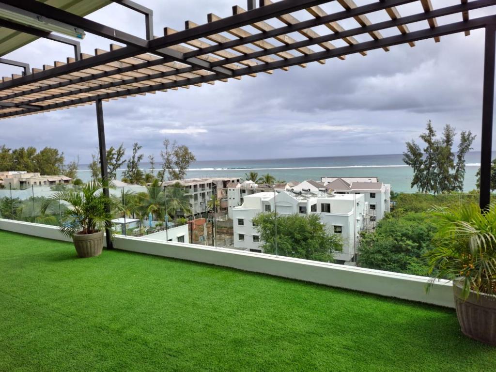 a balcony with green grass and white buildings at Luxury Apartment 150 m from the beach in Flic-en-Flac