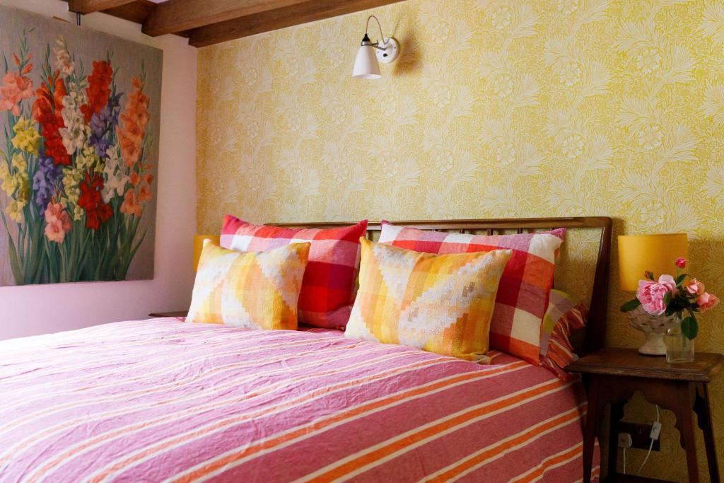 1 dormitorio con 1 cama con almohadas de colores y una pintura en 15 Bond Street The Butler Collection, en Arundel