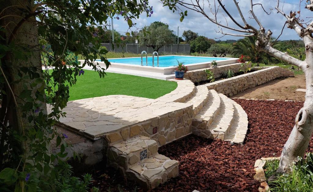 a stone bench in front of a swimming pool at Casa Alegria - Apartment Vista da Serra in Tomar