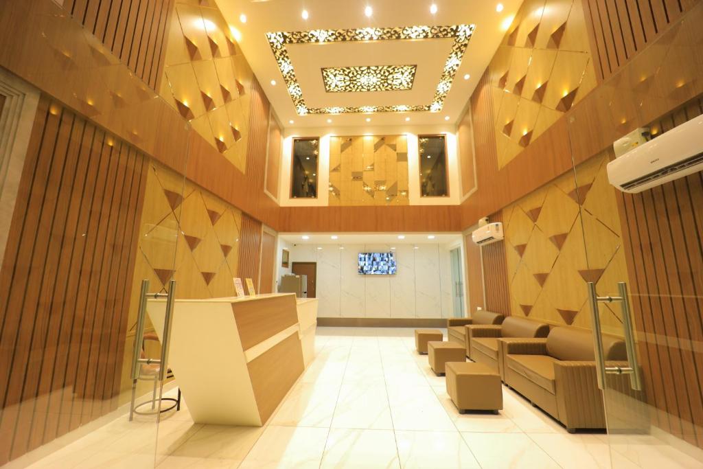 a lobby with a waiting area with chairs and a ceiling at JKInn in Vellore