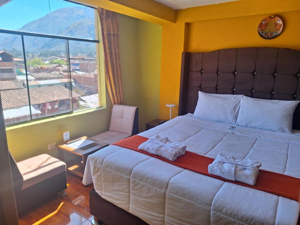 - une chambre avec un grand lit et une grande fenêtre dans l'établissement Chaska valle Inn, à Urubamba