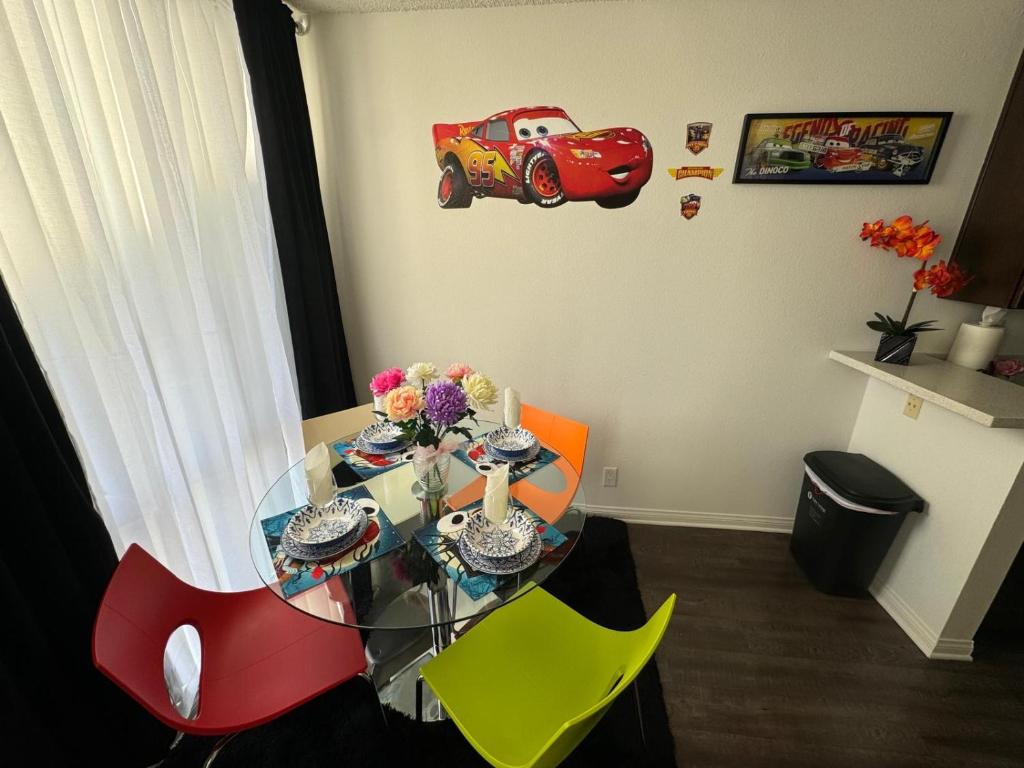 a dining room with a glass table and a red car on the wall at Mario, Harry Potter & Disney Loft Universal Studios 10min loft apartment in Los Angeles