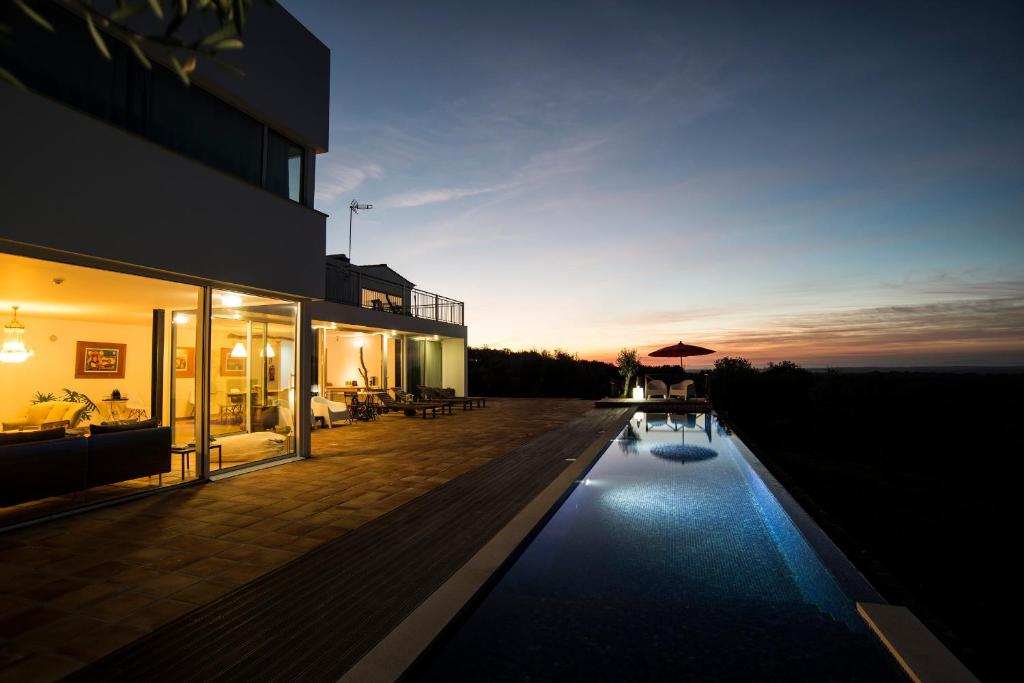 una casa con piscina frente a un edificio en A Serenada Enoturismo, en Grândola