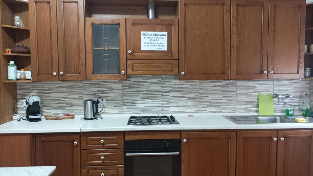 a kitchen with wooden cabinets and a stove top oven at La Casetta Di Cotignola in Cotignola