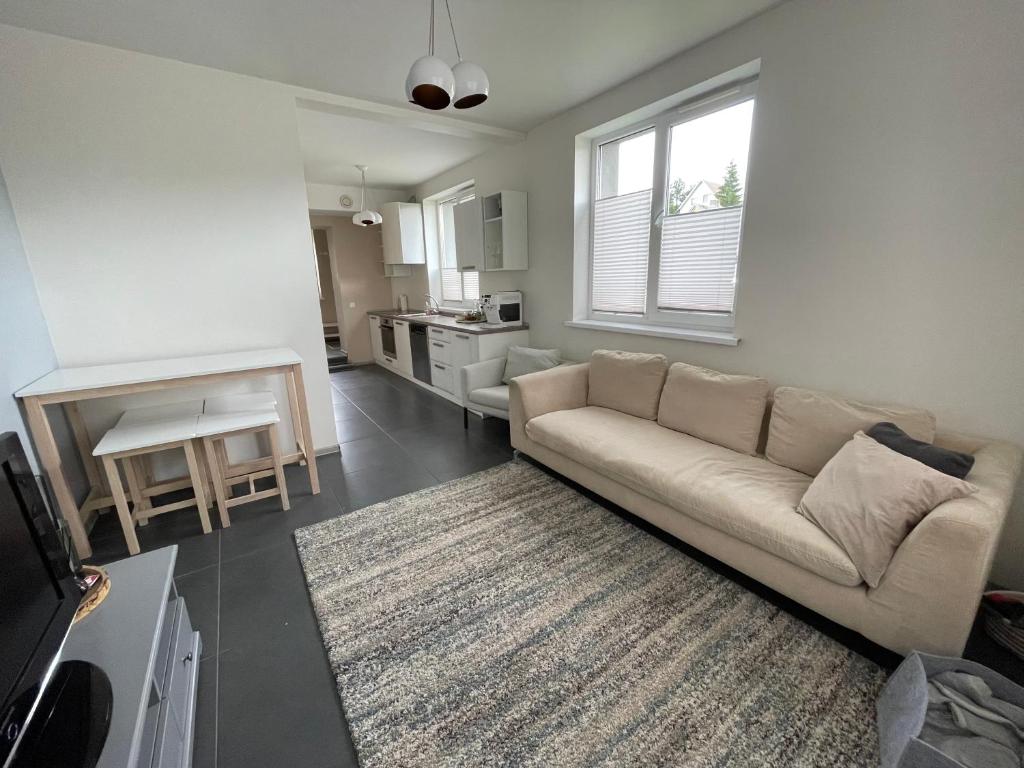 a living room with a couch and a kitchen at JZ apartamentai in Kelmė