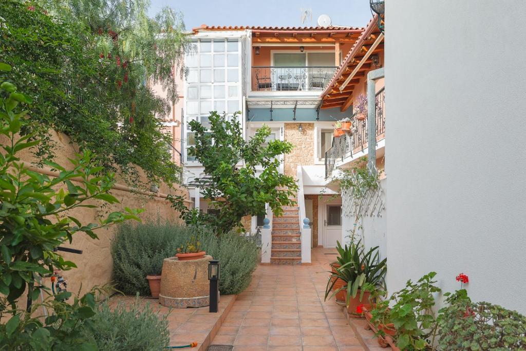 une cour d'un immeuble avec des plantes et des escaliers dans l'établissement Stenaki - Apartments in Aegina Town, à Égine